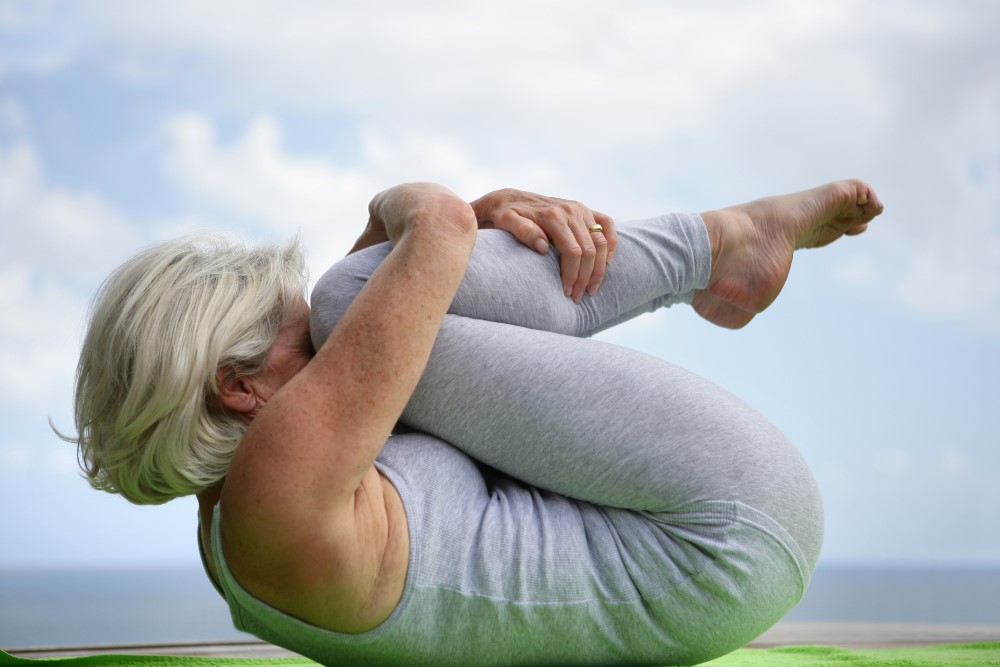 Ældre kvinde der dyrker yoga